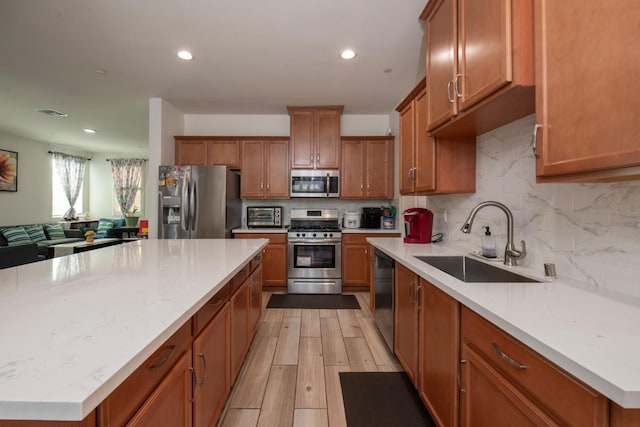 4865 E Alexander Ave, Fresno, CA 93725 - kitchen with appliances with stainless steel finishes, brown cabinets, backsplash, recessed lighting, and a kitchen island