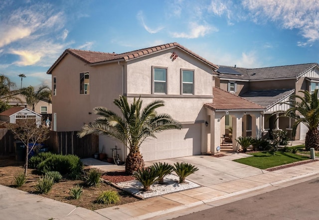 4865 E Alexander Ave, Fresno, CA 93725 - mediterranean / spanish home with a garage, stucco siding, solar panels, and concrete driveway