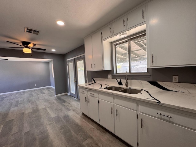 773 9th St, Orange Cove, CA 93646 - kitchen with visible vents, dark wood-style flooring, white cabinetry, and a sink
