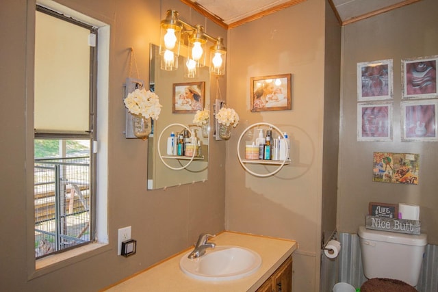bathroom featuring a chandelier, ornamental molding, toilet, and vanity
