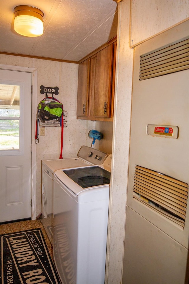 laundry area featuring separate washer and dryer, a heating unit, and cabinet space