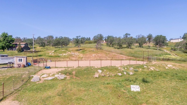 view of yard with a rural view and fence