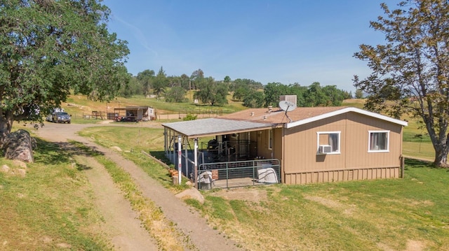 rear view of house with an exterior structure, an outdoor structure, cooling unit, and dirt driveway