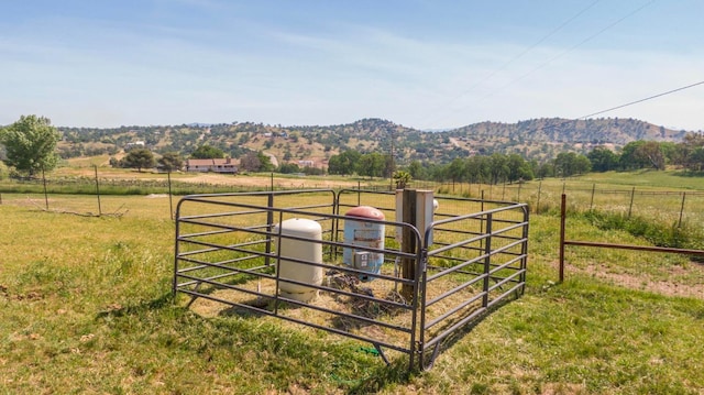 view of gate featuring a rural view, fence, and a mountain view