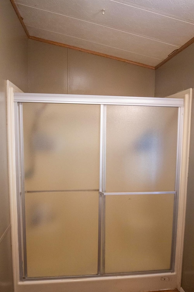 bathroom featuring a shower stall and crown molding