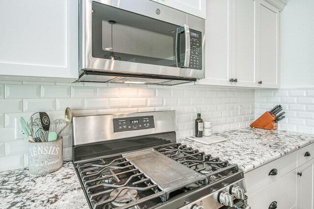 408 Grant Ave W, Madera, CA 93636 - kitchen featuring light stone counters, appliances with stainless steel finishes, decorative backsplash, and white cabinetry