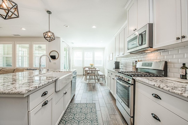 408 Grant Ave W, Madera, CA 93636 - kitchen with decorative backsplash, recessed lighting, white cabinets, a sink, and stainless steel appliances