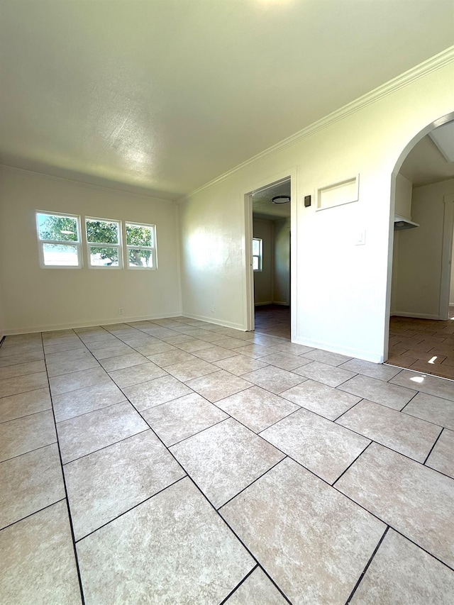 2824 C St, Selma, CA 93662 - unfurnished room with crown molding, arched walkways, light tile patterned flooring, and baseboards