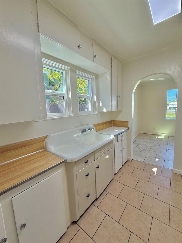 2824 C St, Selma, CA 93662 - kitchen featuring a sink, arched walkways, light tile patterned flooring, and plenty of natural light
