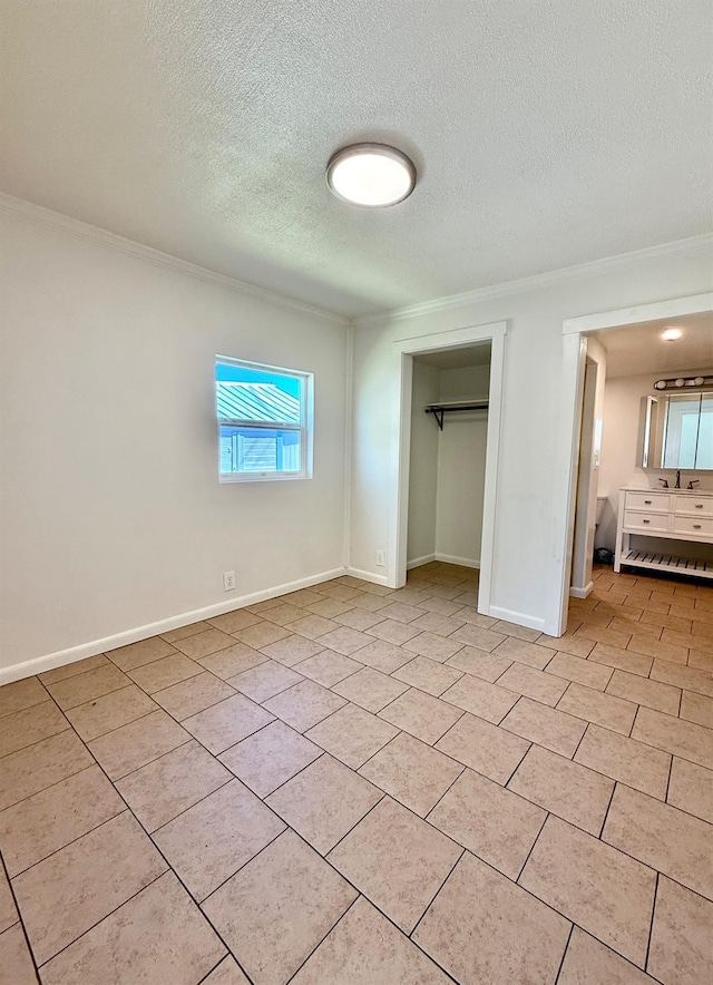 2824 C St, Selma, CA 93662 - unfurnished bedroom with crown molding, a textured ceiling, a closet, light tile patterned floors, and baseboards