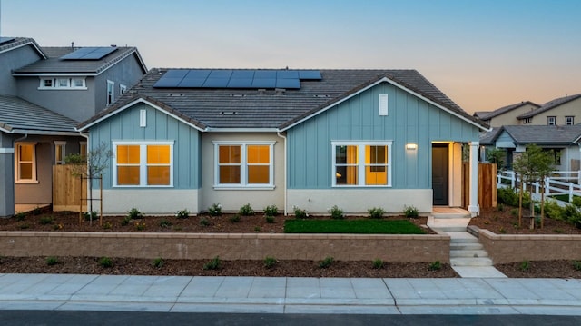 276 Huckleberry Ln S, Madera, CA 93636 - view of front of home with fence, board and batten siding, and solar panels