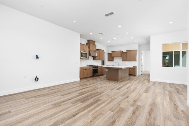 276 Huckleberry Ln S, Madera, CA 93636 - kitchen with appliances with stainless steel finishes, a sink, light countertops, an island with sink, and open floor plan