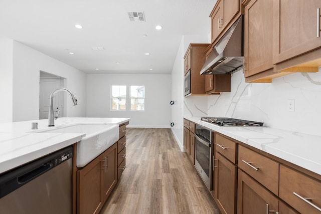 276 Huckleberry Ln S, Madera, CA 93636 - kitchen with appliances with stainless steel finishes, light stone countertops, a sink, light wood-style floors, and under cabinet range hood