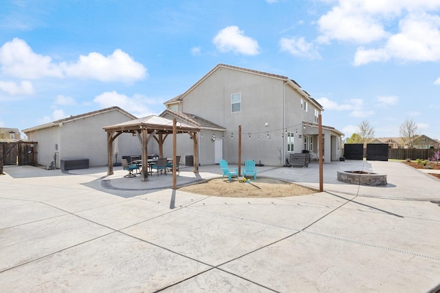 3887 N Condor Ct, Sanger, CA 93657 - rear view of property featuring an outdoor fire pit, a gazebo, a patio area, and stucco siding