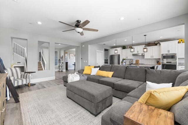 3887 N Condor Ct, Sanger, CA 93657 - living area with light wood-type flooring, ceiling fan, stairs, and recessed lighting