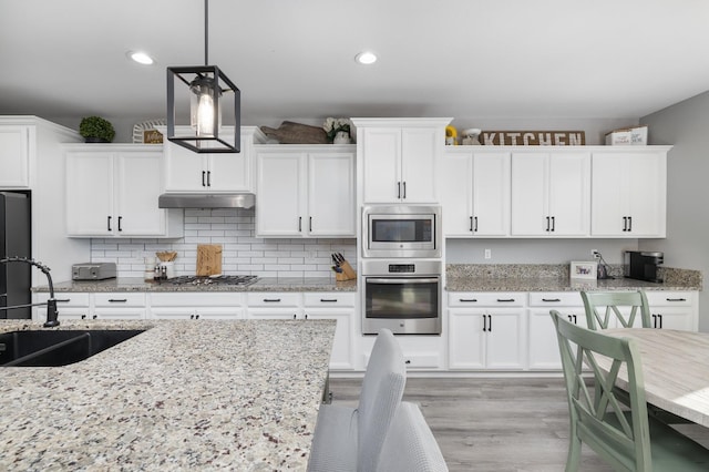3887 N Condor Ct, Sanger, CA 93657 - kitchen featuring stainless steel appliances, white cabinetry, hanging light fixtures, and recessed lighting