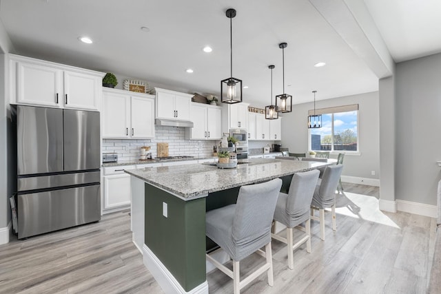 3887 N Condor Ct, Sanger, CA 93657 - kitchen featuring appliances with stainless steel finishes, white cabinetry, light wood finished floors, a center island with sink, and recessed lighting