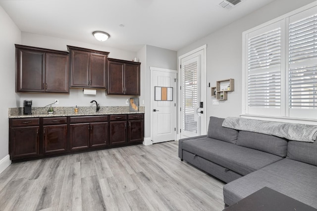 3887 N Condor Ct, Sanger, CA 93657 - kitchen featuring light wood-style floors, dark brown cabinets, and light stone counters
