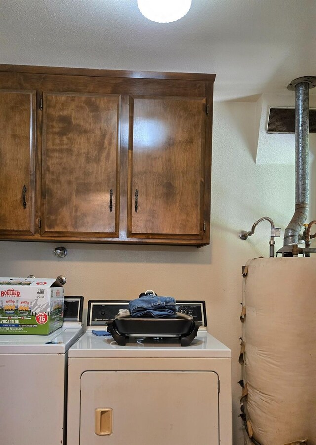 26174 Haley Way, Madera, CA 93638 - clothes washing area featuring water heater, washing machine and clothes dryer, and cabinet space