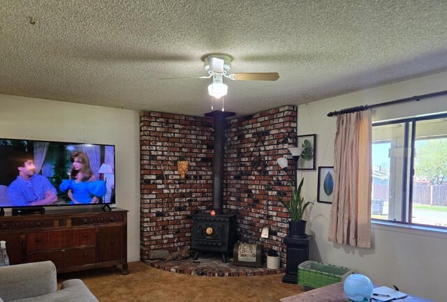 26174 Haley Way, Madera, CA 93638 - living area with a textured ceiling, a wood stove, a ceiling fan, and carpet