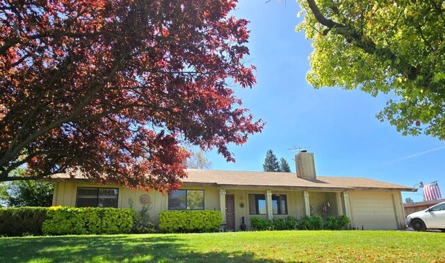 26174 Haley Way, Madera, CA 93638 - ranch-style home with a chimney, a garage, and a front lawn