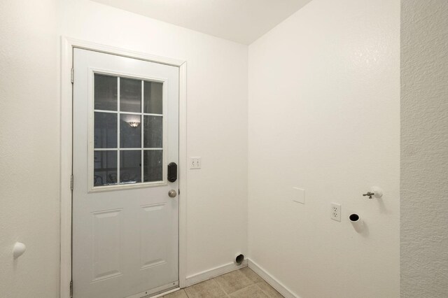 washroom featuring baseboards, laundry area, light tile patterned floors, and electric dryer hookup