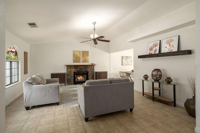 living area with visible vents, a fireplace, a ceiling fan, lofted ceiling, and light tile patterned floors