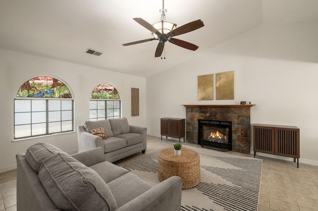 living area featuring lofted ceiling, light tile patterned floors, ceiling fan, visible vents, and a fireplace