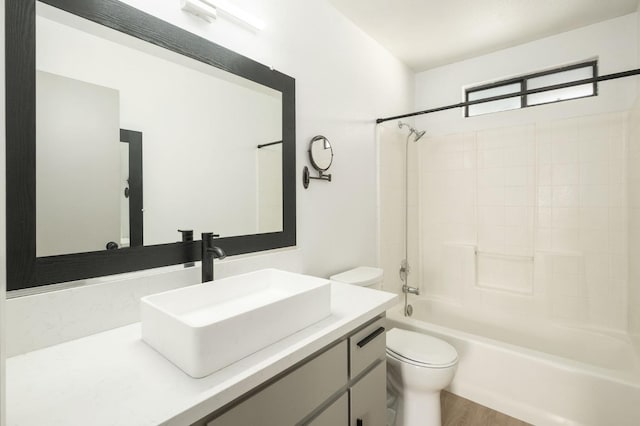 bathroom with bathtub / shower combination, toilet, vanity, and wood finished floors