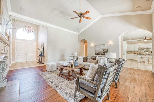 1643 E Shadow Glen Dr, Fresno, CA 93730 - living area with arched walkways, ceiling fan with notable chandelier, light wood-type flooring, and high vaulted ceiling