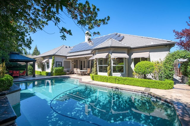 1643 E Shadow Glen Dr, Fresno, CA 93730 - back of house featuring solar panels, outdoor dining area, an outdoor pool, a gazebo, and a patio