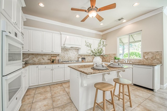1643 E Shadow Glen Dr, Fresno, CA 93730 - kitchen featuring white cabinets, light stone counters, white appliances, custom range hood, and visible vents