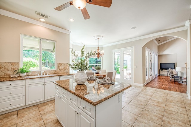 1643 E Shadow Glen Dr, Fresno, CA 93730 - kitchen with a kitchen island, visible vents, light tile patterned floors, and light stone counters