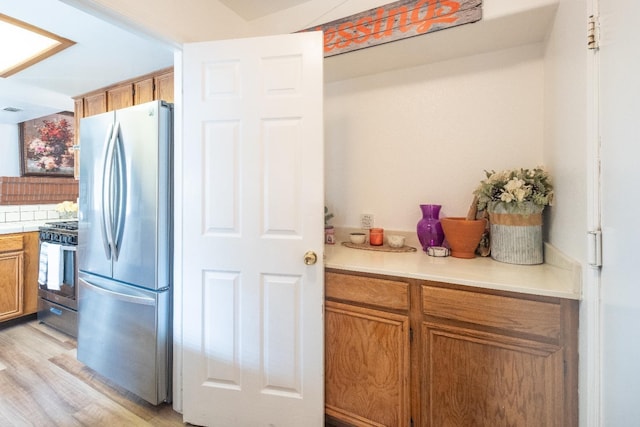 1295 E Athens Ave, Fresno, CA 93720 - kitchen with appliances with stainless steel finishes, light wood-style floors, light countertops, and brown cabinets