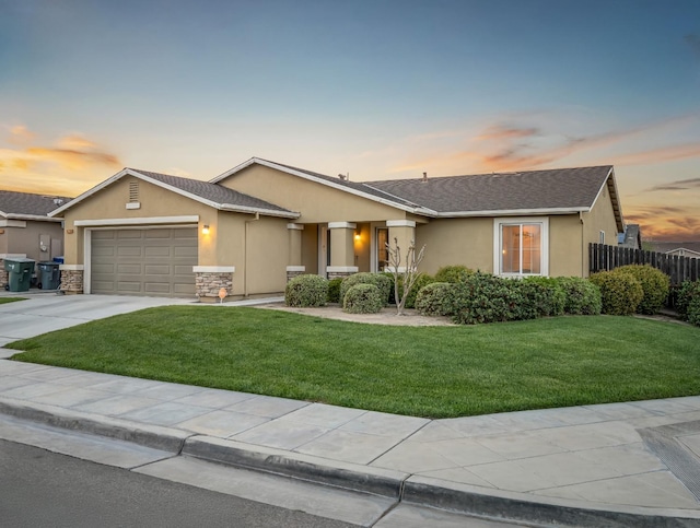 ranch-style home featuring a front lawn, an attached garage, concrete driveway, and stucco siding