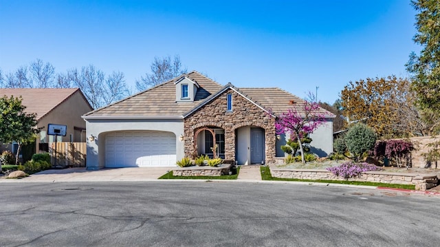 11 W Serena Ave, Clovis, CA 93619 - view of front facade featuring stone siding, a garage, stucco siding, and concrete driveway