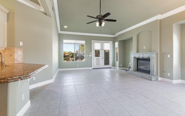 11 W Serena Ave, Clovis, CA 93619 - unfurnished living room with light tile patterned floors, ceiling fan, crown molding, baseboards, and a fireplace