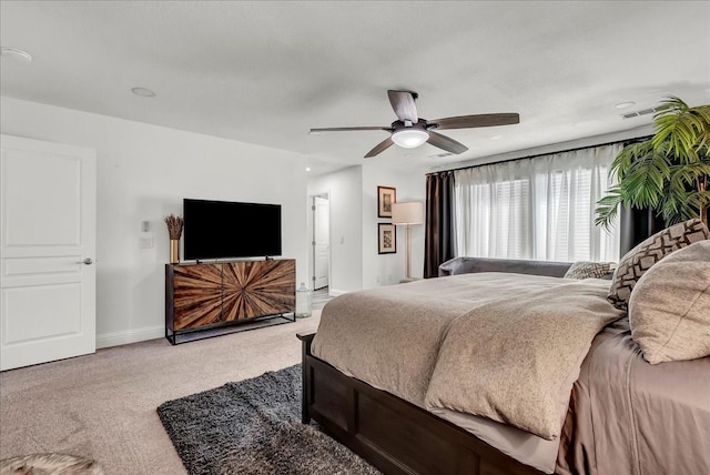 bedroom featuring visible vents, baseboards, light colored carpet, and ceiling fan