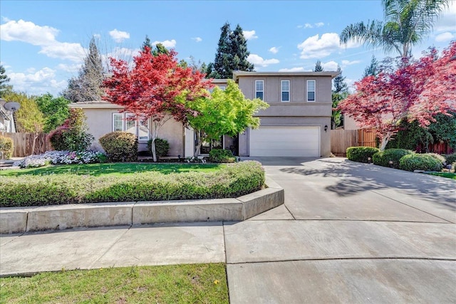 view of front of house featuring stucco siding, fence, driveway, a front yard, and a garage