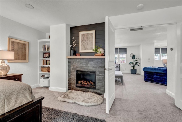 carpeted bedroom featuring baseboards, visible vents, and a fireplace