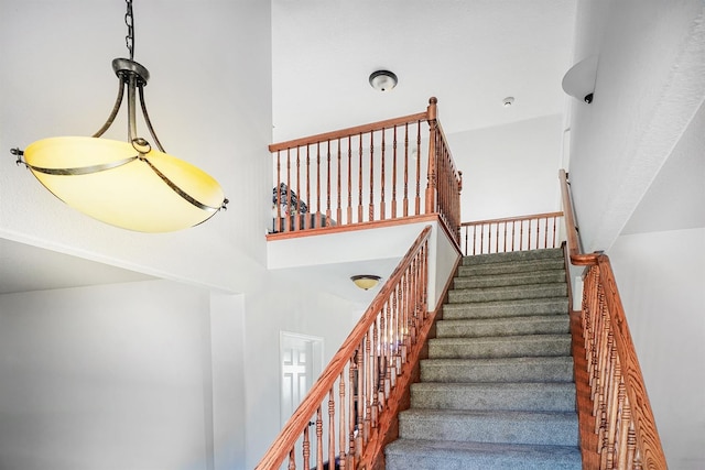 staircase featuring a towering ceiling