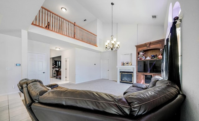 living area with a notable chandelier, high vaulted ceiling, a tiled fireplace, baseboards, and visible vents