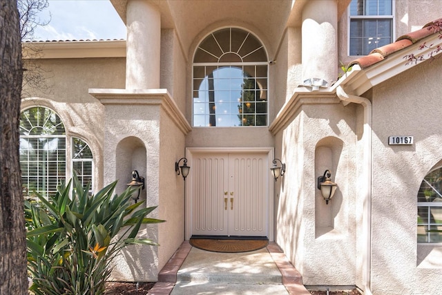 doorway to property featuring stucco siding