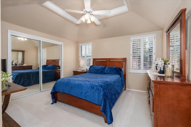 bedroom with ceiling fan, light carpet, baseboards, vaulted ceiling, and a closet