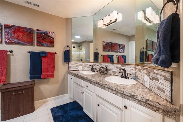 bathroom with a sink, tile patterned floors, a stall shower, and visible vents