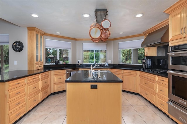 kitchen featuring crown molding, an island with sink, wall chimney exhaust hood, a warming drawer, and stainless steel appliances