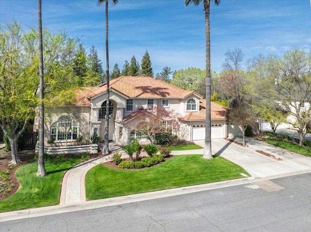 mediterranean / spanish-style house featuring stucco siding, driveway, a tile roof, and a front yard
