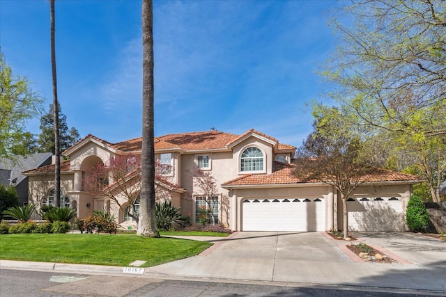 view of front of home with a tiled roof, a garage, a front lawn, concrete driveway, and stucco siding