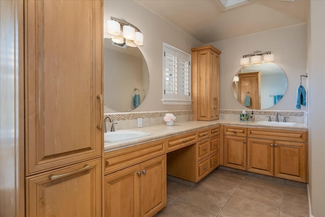 bathroom featuring backsplash, double vanity, a sink, and tile patterned flooring
