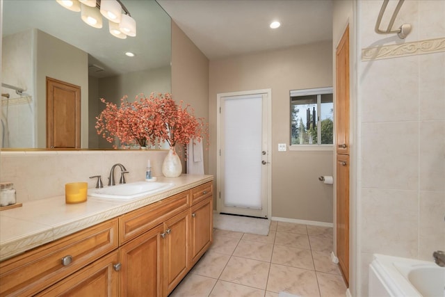 bathroom with tile patterned flooring, vanity, a bathtub, baseboards, and tasteful backsplash